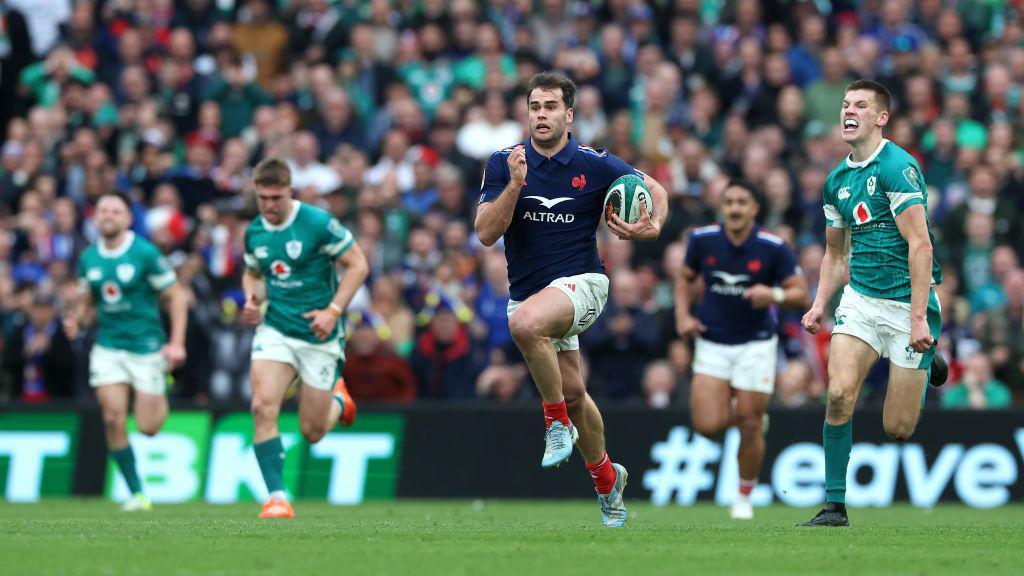 Damian Penaud running with the ball, on his way to scoring a try against Ireland.