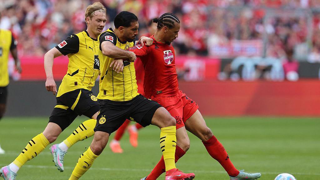 Emre Can and Leroy Sane tussle for the ball