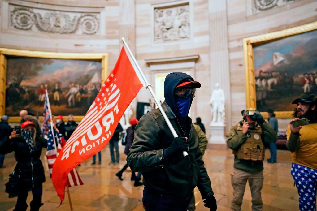 A man holds a trump flag in the capitol