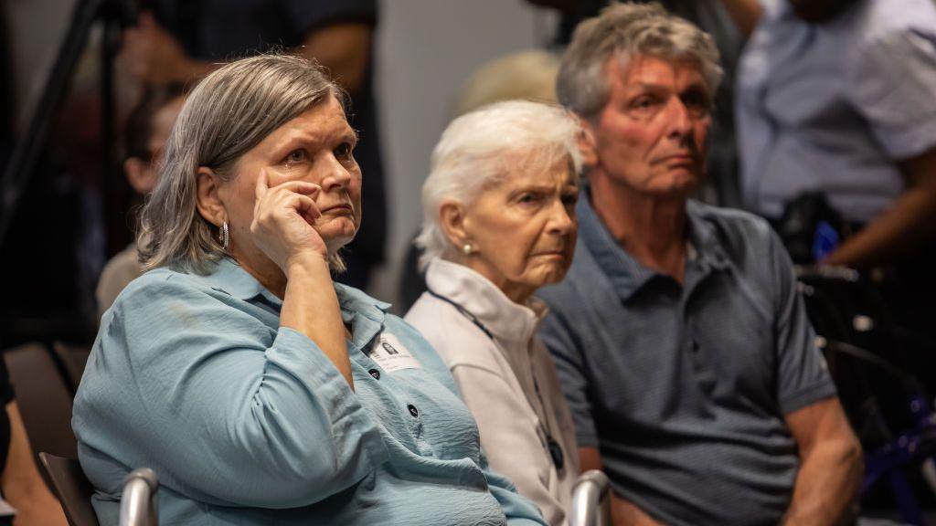 Diane VanderMolen, wiping a tear from her eye, sits during a legal hearing with Joan Anderson VanderMolen