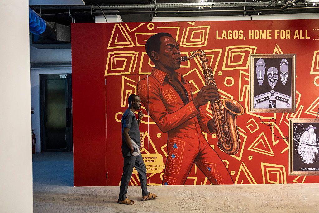 A man walks past a painted wall depicting afrobeat pioneer Fela Kuti.