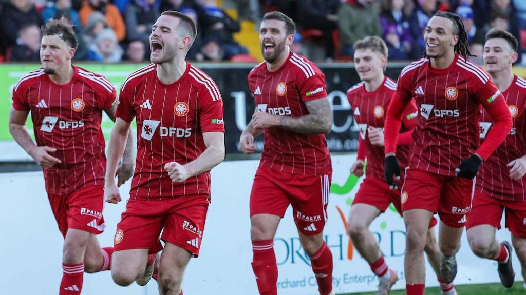 Luke Wilson es perseguido por sus compañeros de Portadown