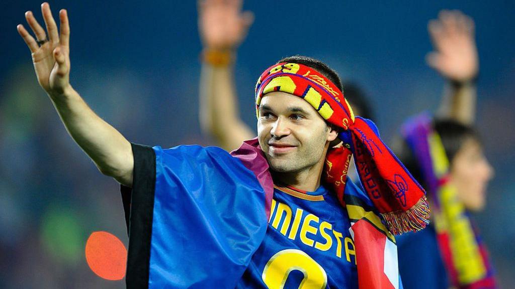 Iniesta, with a scarf wrapped around his head, celebrates winning the Champions League