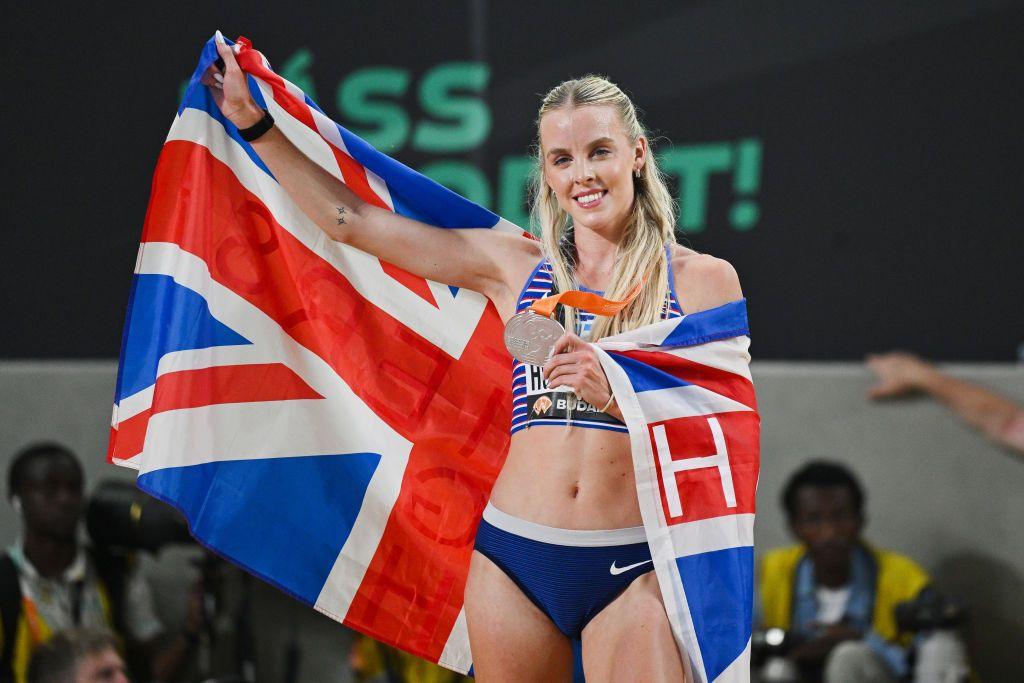 Runner Keely Hodgkinson holding a Union Jack flag and a silver medal