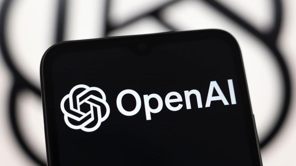 A tablet screen with the words "OpenAI" and its logo in black and white