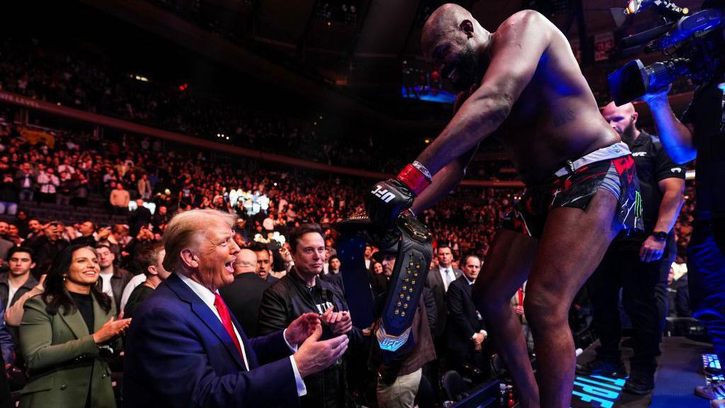 Jon Jones passing his UFC heavyweight title to president-elect Donald Trump