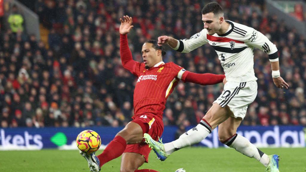 Liverpool defender Virgil van Dijk challenges for the ball with Manchester United defender Diogo Dalot 