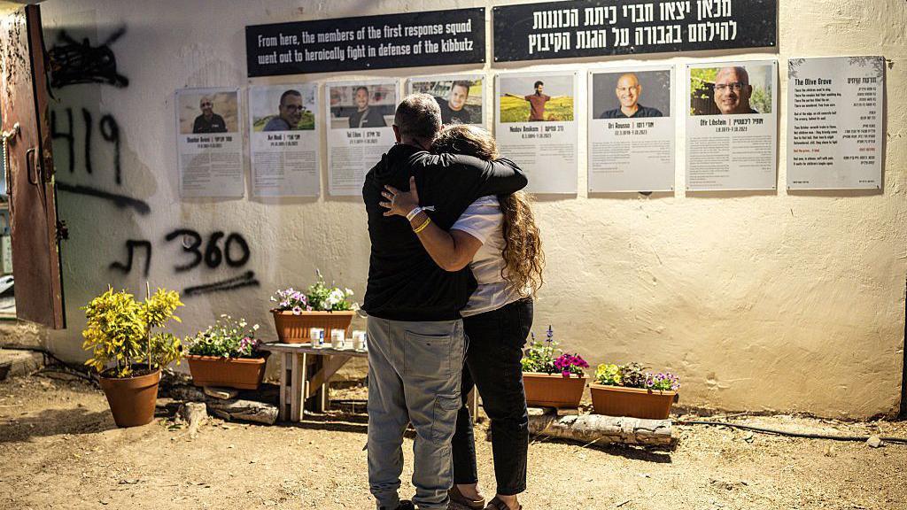 Two people embrace ahead of a memorial ceremony for the victims of the 2023 October 7 attacks at the Nova Festival grounds in Reim in southern Israel on the second anniversary of the attacks on October 7, 2025