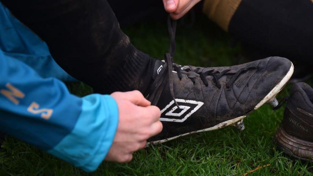 A stock image of someone tying a football boot