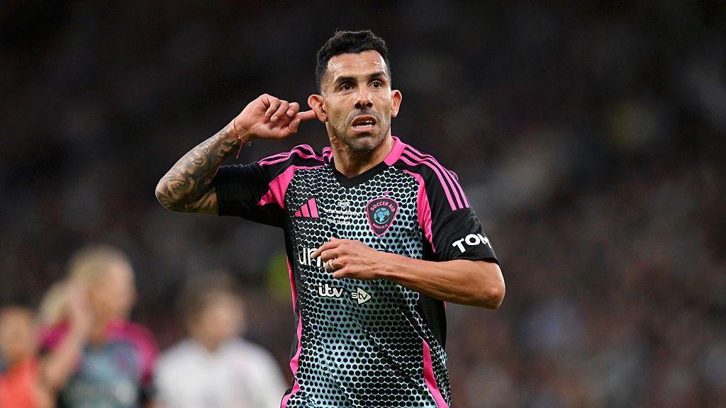 Carlos Tevez points to his ear after scoring a goal