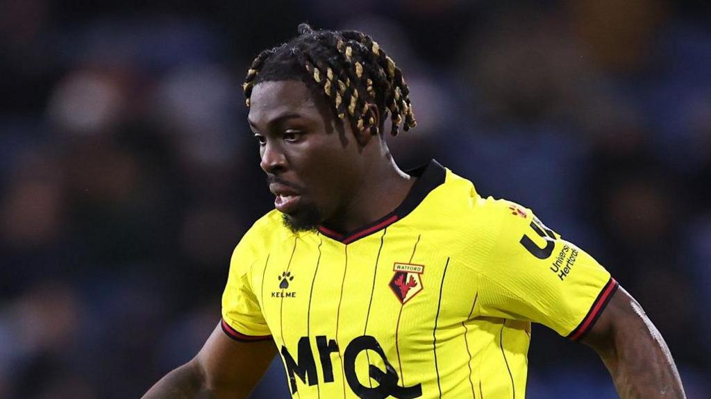 Festy Ebosele playing for Watford in their home shirt