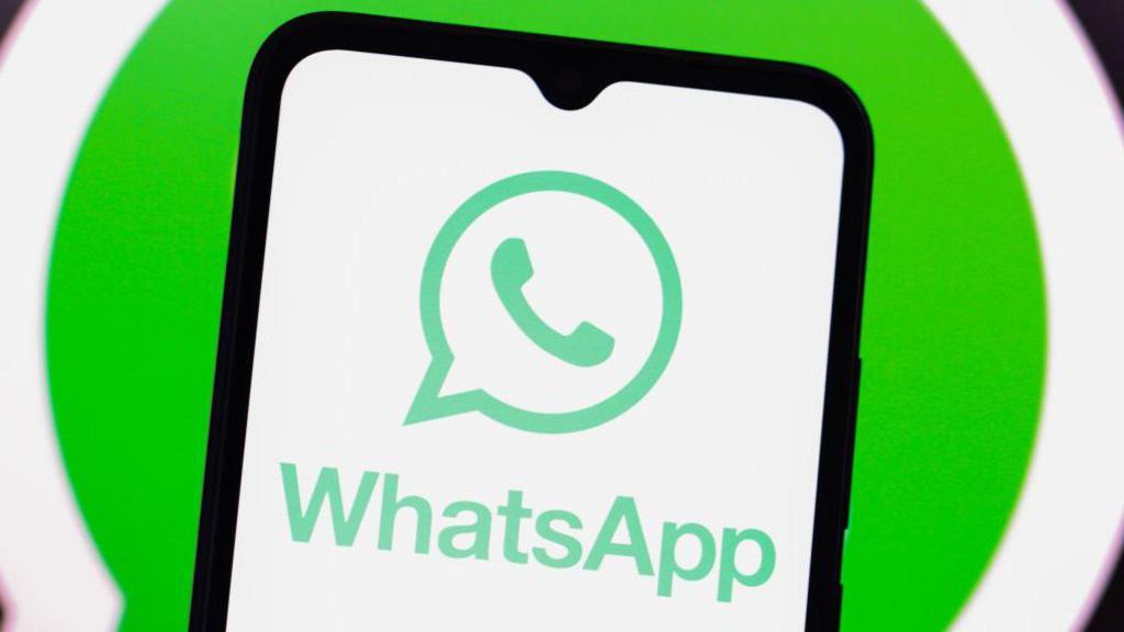 WhatsApp logo displayed on a smartphone against a green and white background