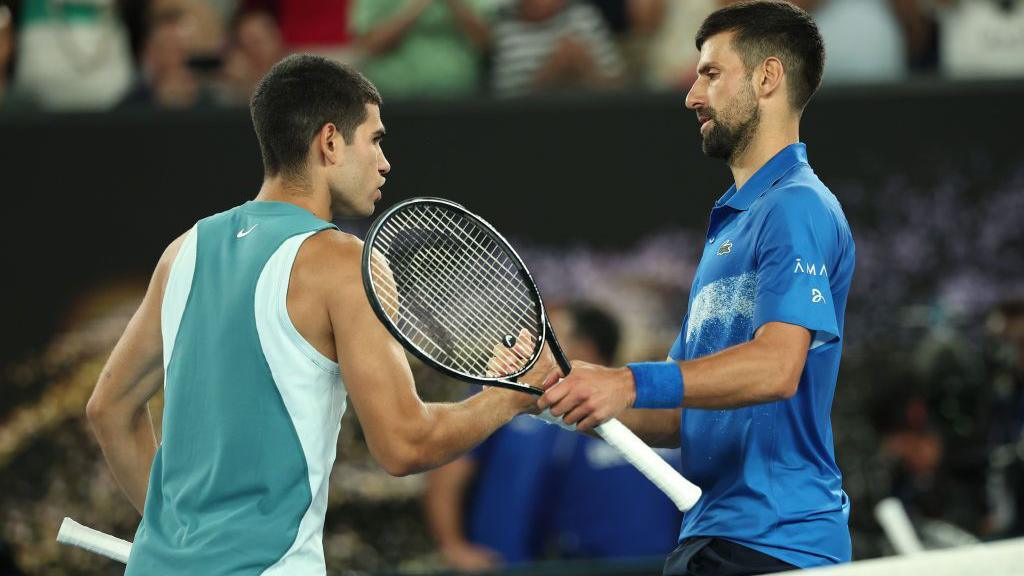 Carlos Alcaraz and Novak Djokovic shake hands at the net