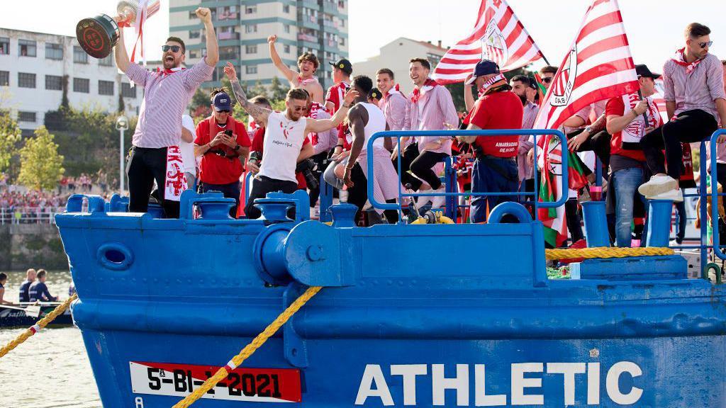 Athletic players celebrate on a barge