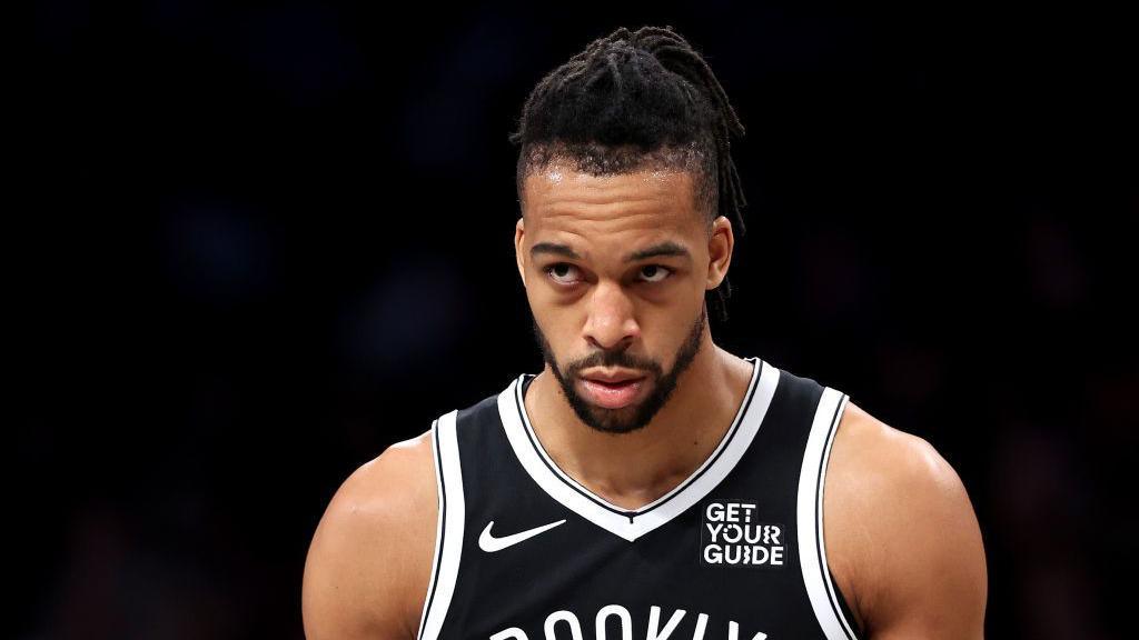 Tosan Evbuomwan looks on in a Brooklyn Nets jersey