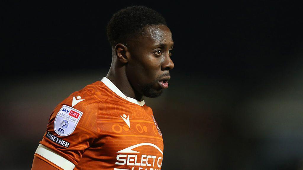 Andy Yiadom looks on while in action for Reading, in his orange shirt