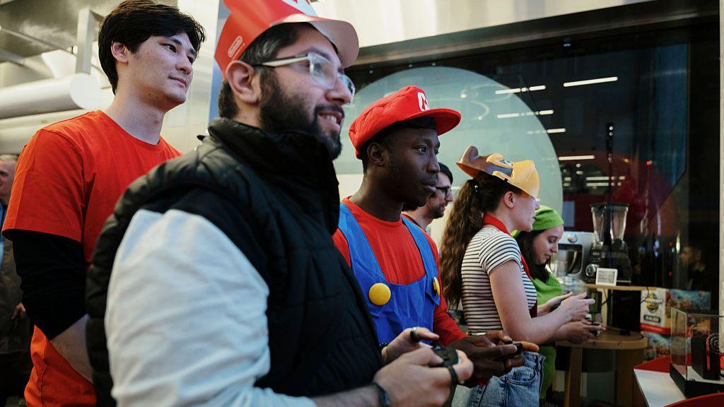 Customers play the Mario Kart video game ahead of the sales launch of the Nintendo Switch 2 gaming console at a store on Oxford Street in London on 4 June 2025.