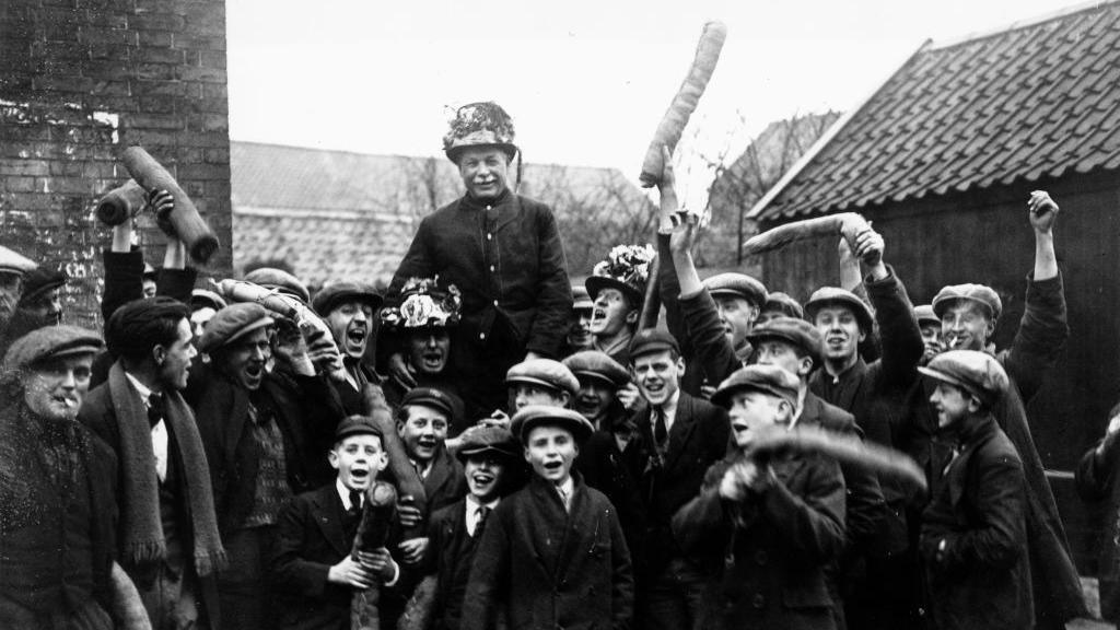 a black and white photo of people taking part in Haxey Hood.