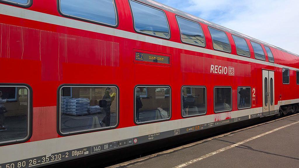 A red DB Regio double-decker train is at the platform of Weiden train station in Weiden, Upper Palatinate, Bavaria, Germany, on April 20, 2025.