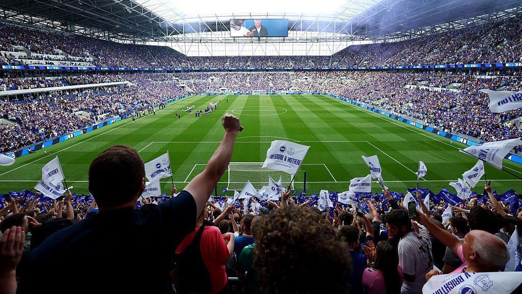 Fans wave flags at Everton's Hill Dickinson Stadium