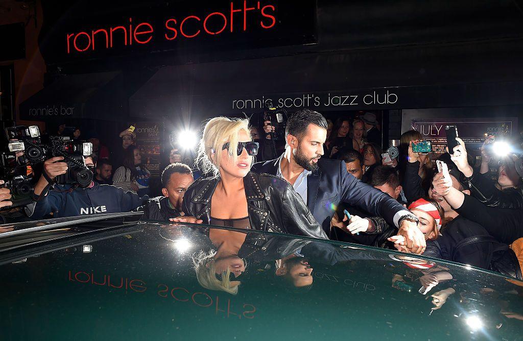 Lady Gaga is surrounded by fans and photographers as she leaves Ronnie Scott's Jazz Club in London