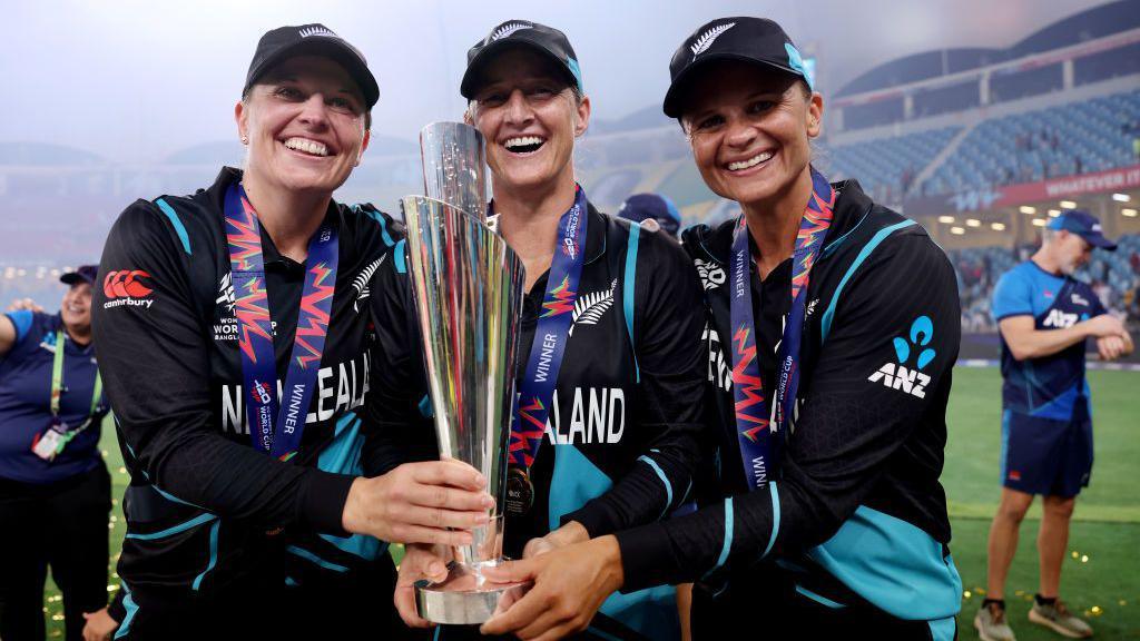 Left to right: Lea Tahuhu, Sophie Devine and Suzie Bates with the Women's T20 World Cup trophy in 2024