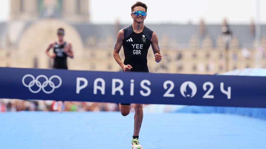 Alex Yee sprints towards the triathlon finish line with Hayden Wilde in the background