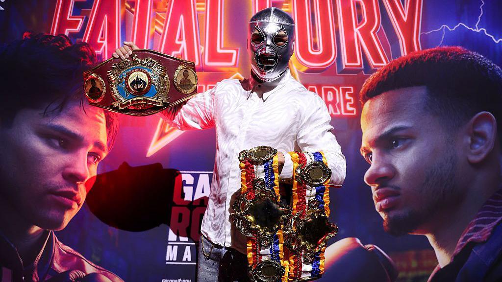 Teofimo Lopez holds up his belts wearing a silver mask on his face