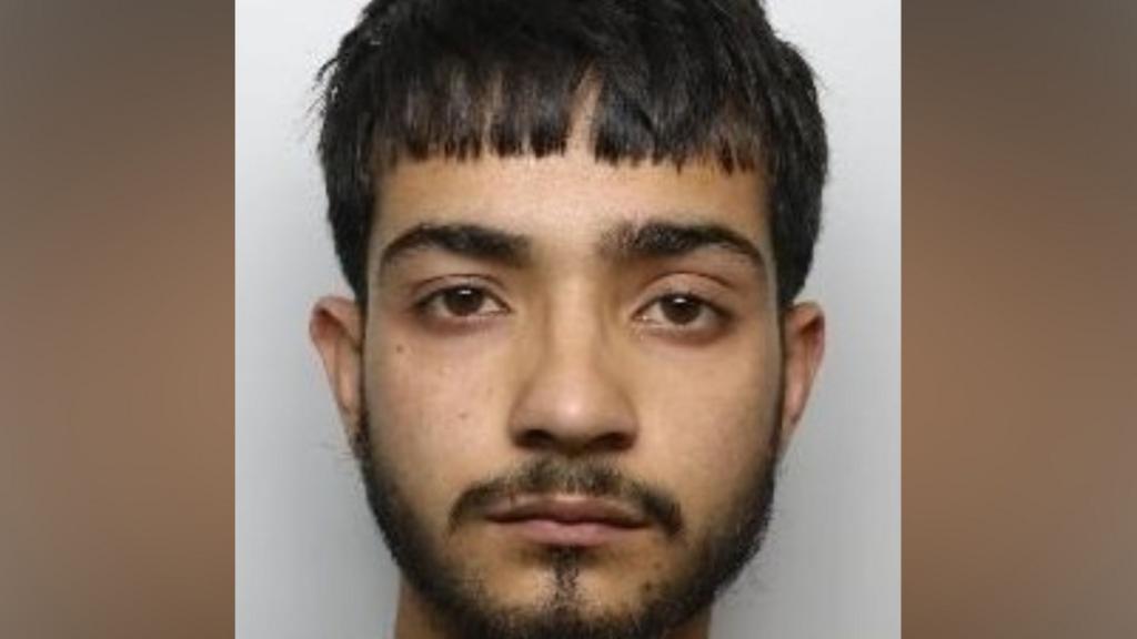 A police mughshot of Zulkernain Ahmed. He has short, dark hair and dark facial hair.