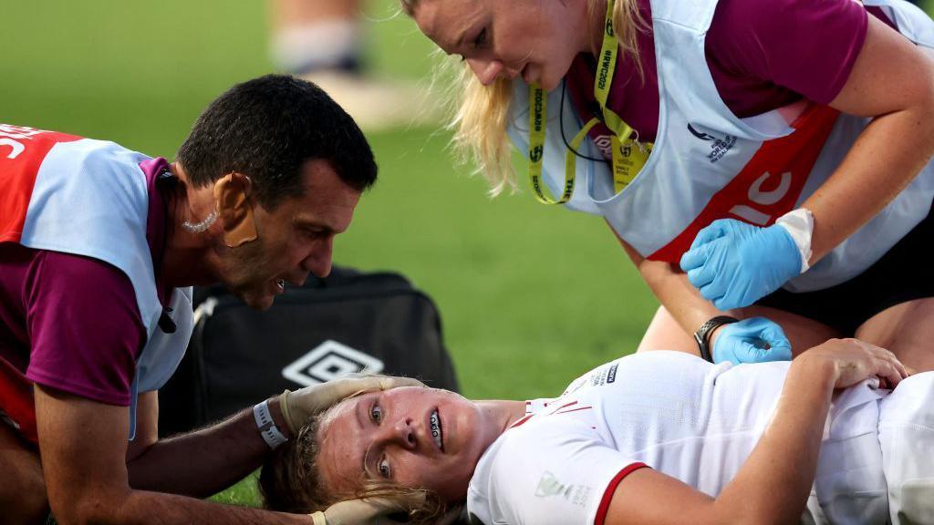 Zoe Aldcroft lies injured on the pitch in Auckland