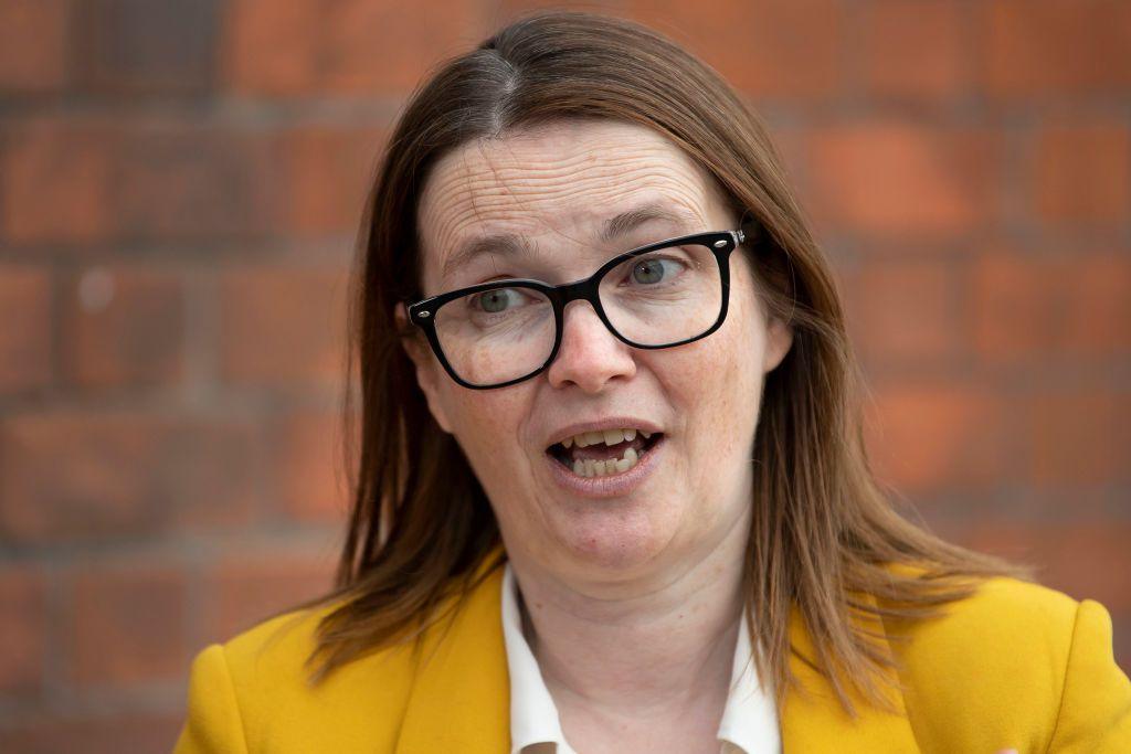 A woman talking. Former politician Kirsty Williams has black framed glasses on and short light-brown hair. She has a yellow jacket on, under which is a white shirt.