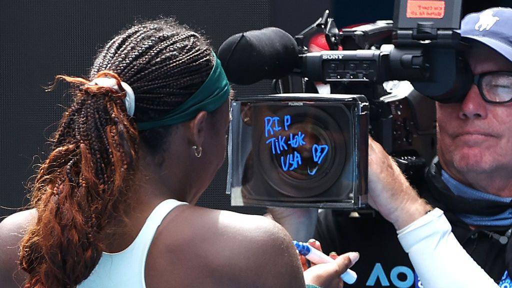 Coco Gauff writes "RIP TIKTOK USA" on a camera at the Australian Open