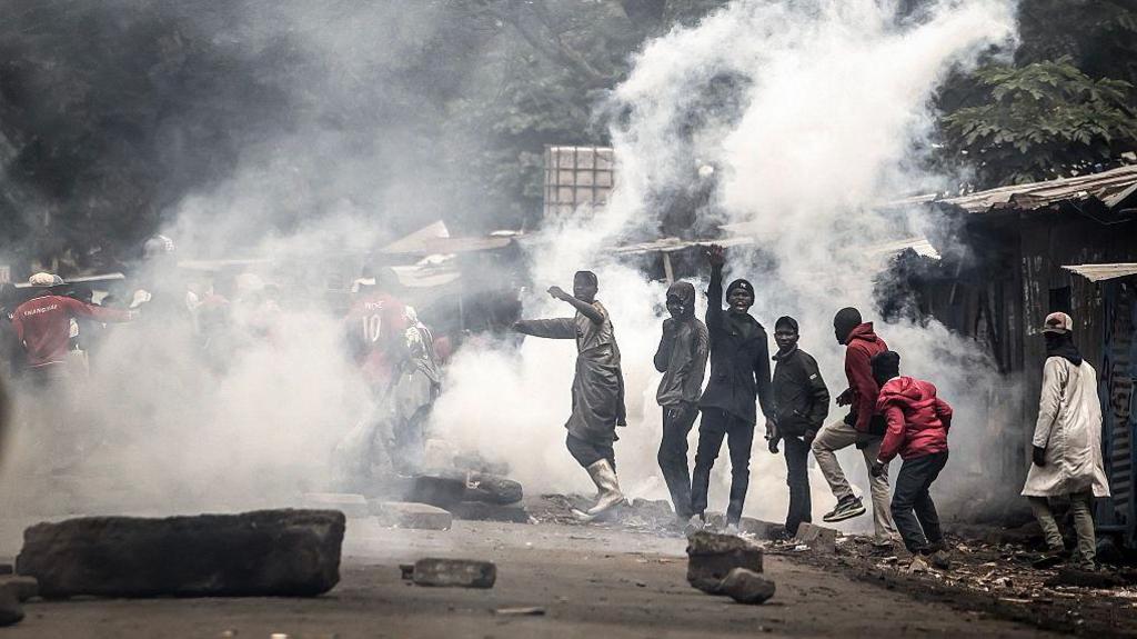 Protesters react amid clouds of tear gas fired by Kenya police officers during clashes at Saba Saba Day demonstrations in Nairobi on July 7, 2025