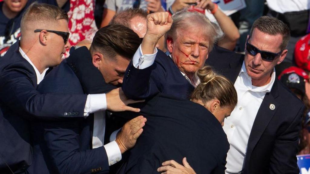 Donald Trump raises a fist after the assassination attempt at a rally in Butler, Pennsylvania