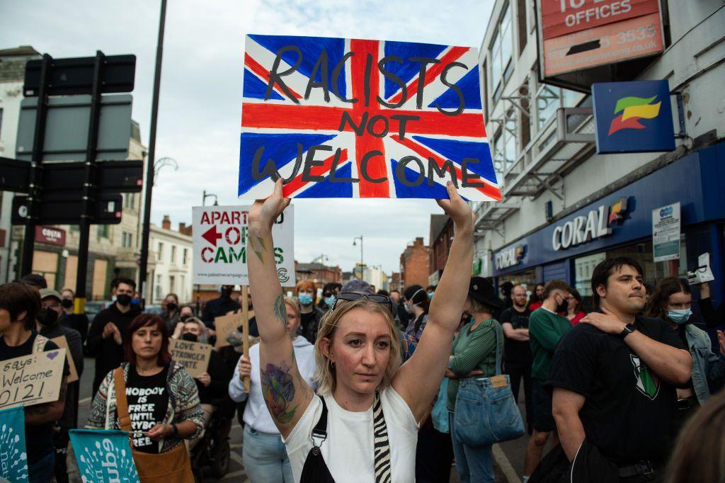 protesters marching and woman holding up sign.