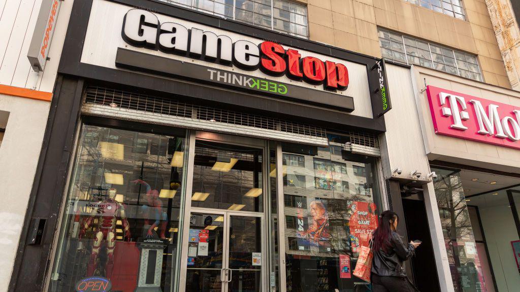 a woman walks past GameStop