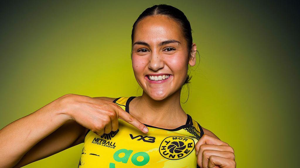 Sophie Fawns wears Manchester Thunder's largely yellow netball outfit