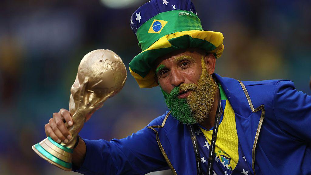 A fan of Brazil with a painted beard and replica World Cup trophy during the FIFA World Cup 2026 Group C match between Scotland and Brazil.