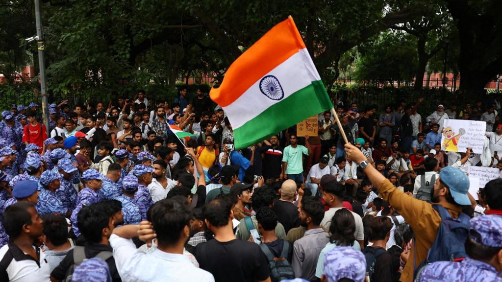 A demonstrators waves an Indian national flag at a protest site ahead of a planned march by supporters of India's Cockroach Janta Party towards parliament on the opening day of its monsoon session