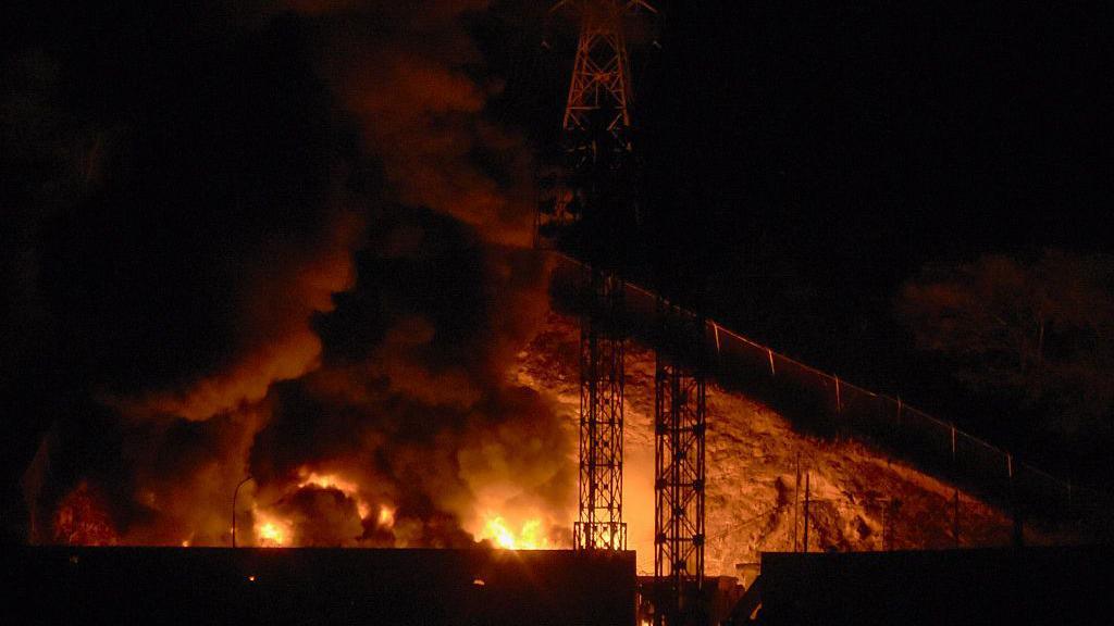 Close up picture of the fire at Fuerte Tiuna showing bright red flames at night.