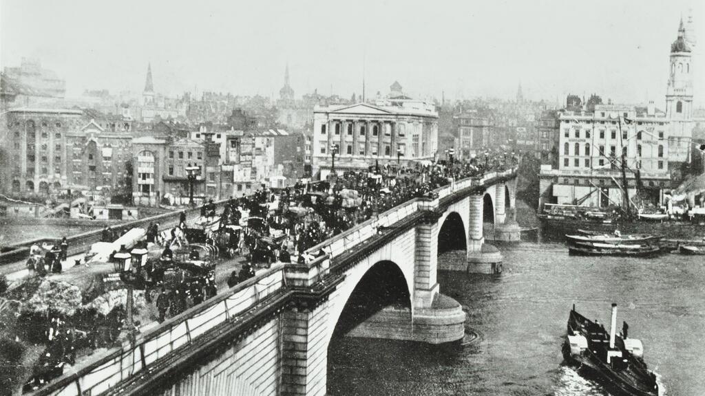 A black and white photograph from 1895 showing horse-drawn traffic on the original London Bridge