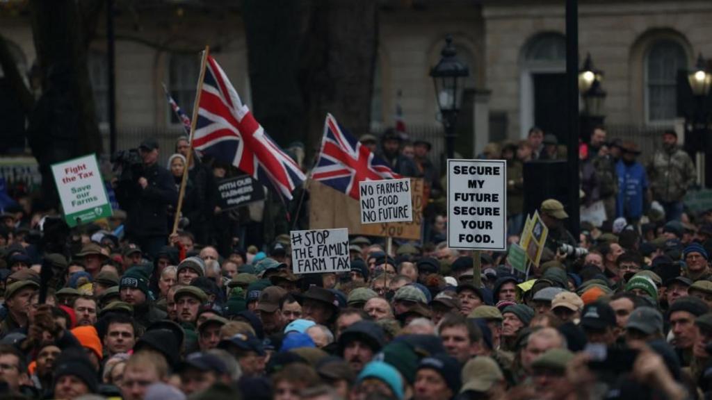 Farmers hold placards during a protest in Westminster 