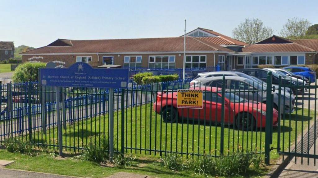 St Martin's Church of England School in Scarborough is a single storey building with the entrance fenced off with a large car park to the right of the image