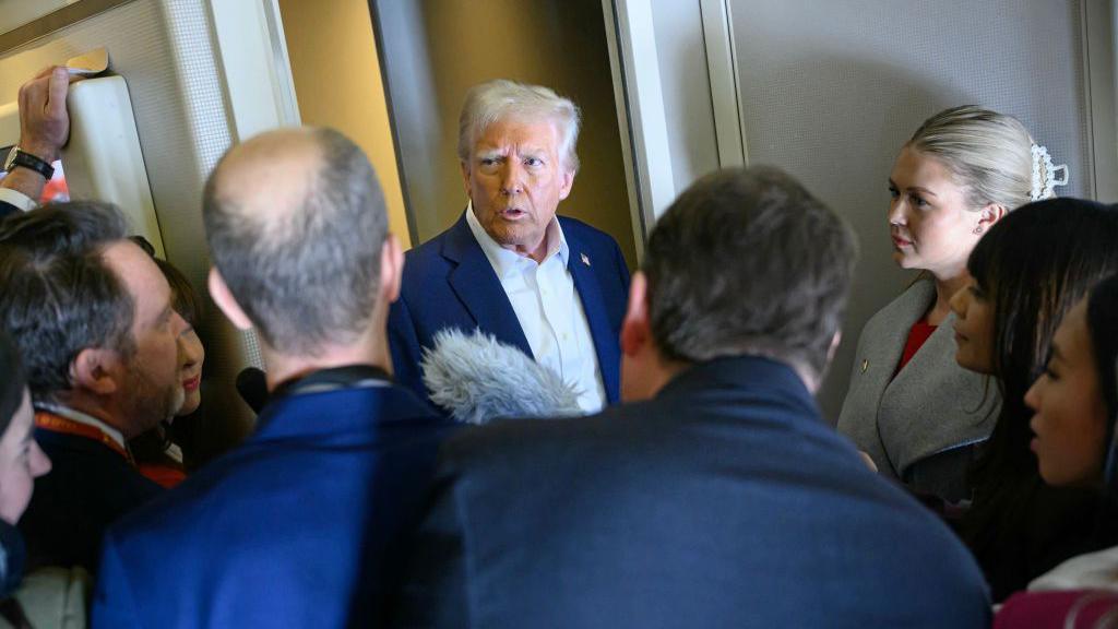 Donald Trump speaking to reporters on board a plane