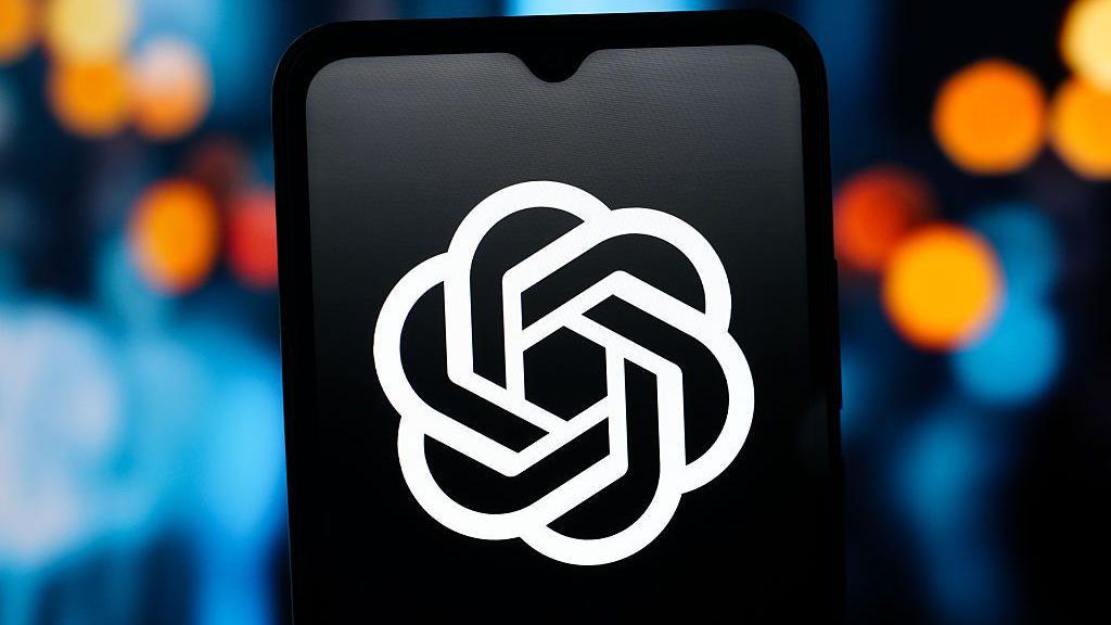 The ChatGPT logo, in white, is visible against the backdrop of a dark phone screen.