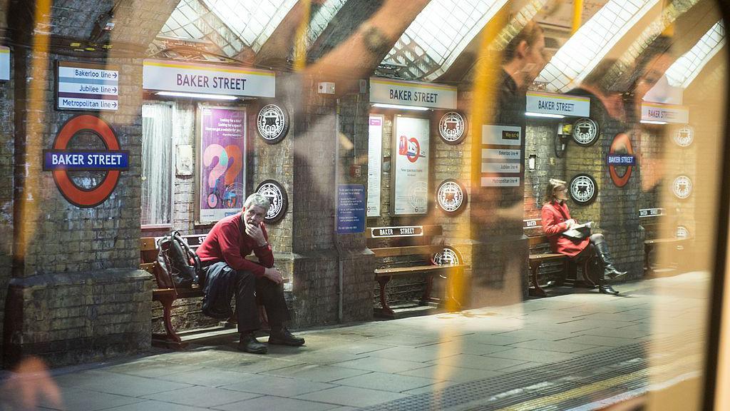Commuters sit on the Baker Street Station platform