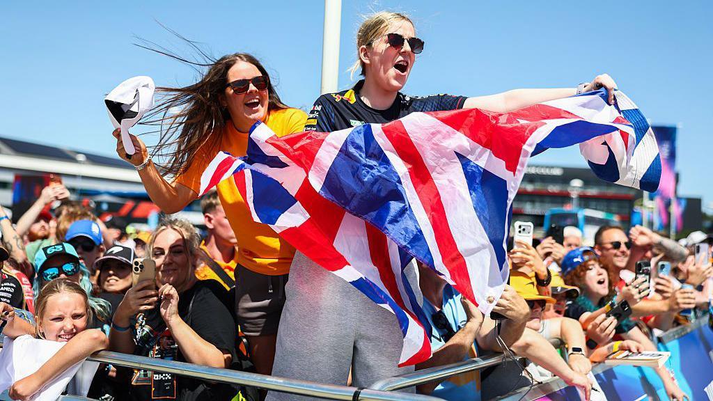 Fans hold up a Union Jack flag at Silverstone 