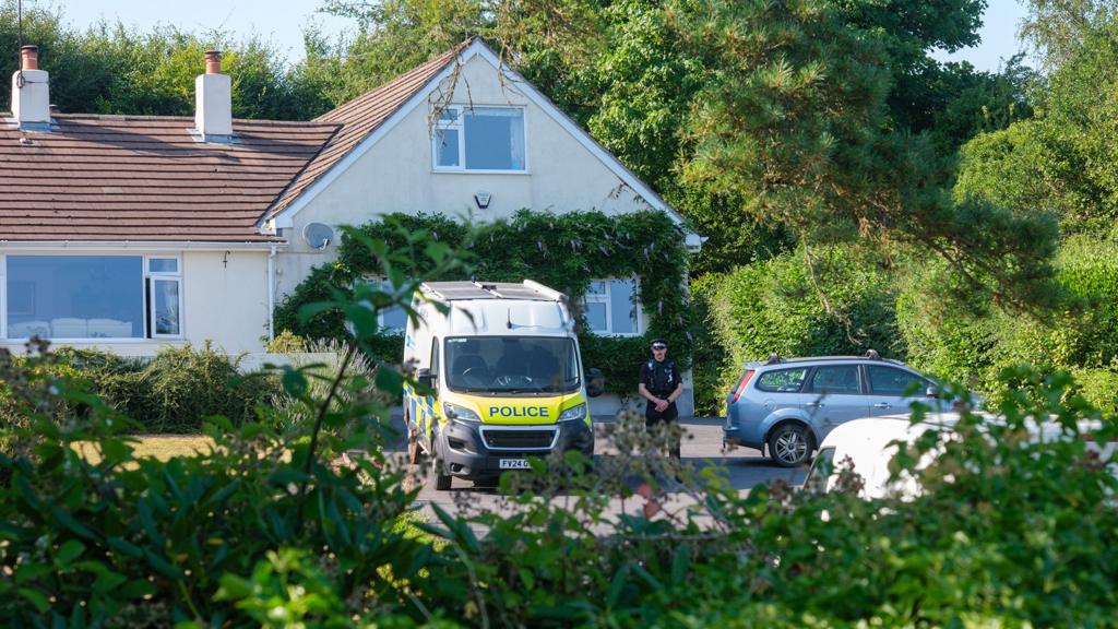 Police car and officer outside Widdecombe house