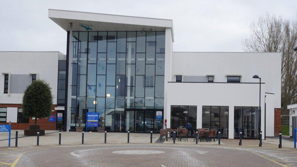 Exterior of Cromer Hospital. It has a large atrium area with dozens of windows and much of the building is painted white.