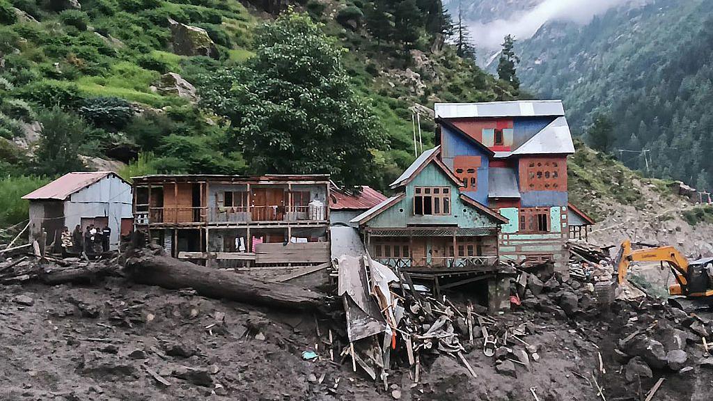 Rescuers (L) inspect the site of a flashflood at a village in Kishtwar district on August 14, 2025.